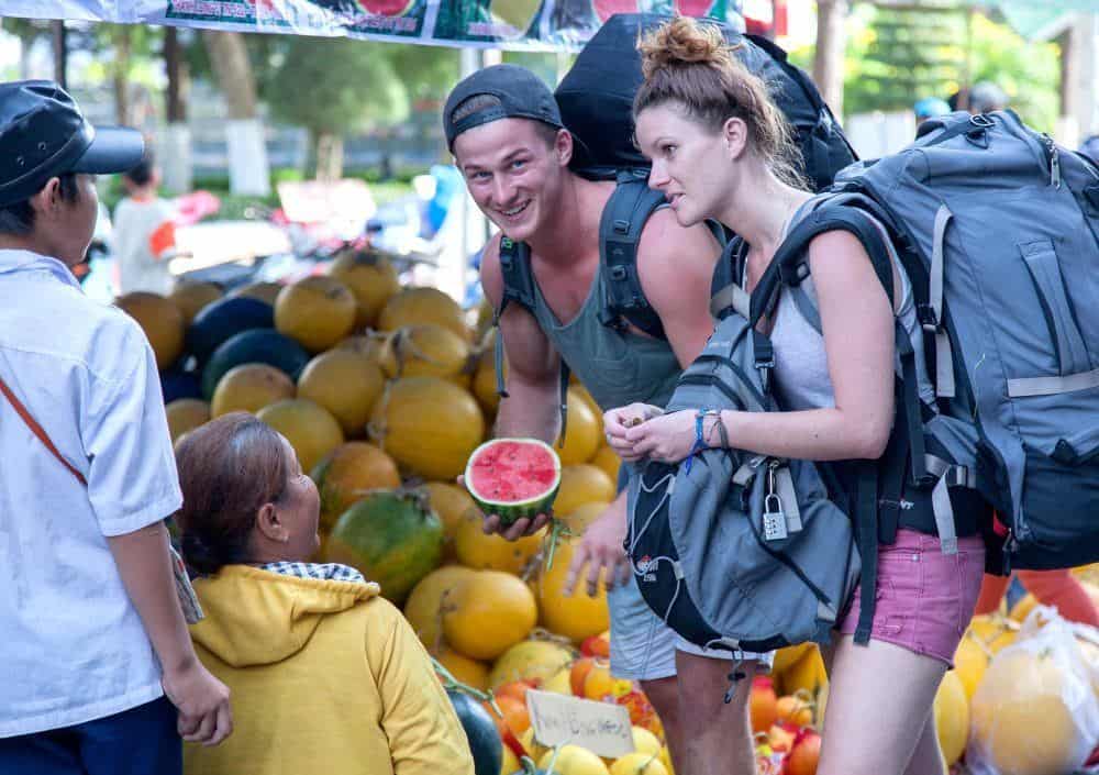 Backpackers che comprano frutta