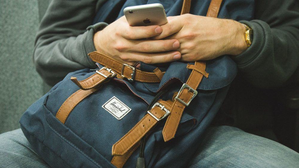 Homme avec sac à dos et téléphone portable